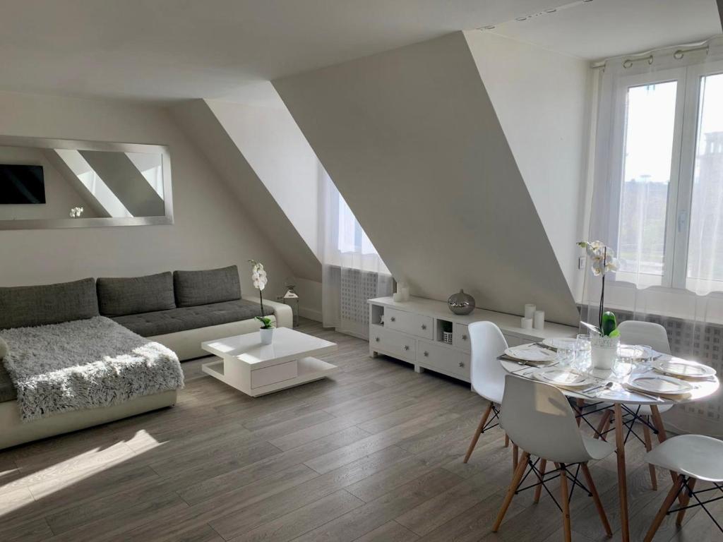 Ideally located , Eiffel Tower view في نويي سور سين: غرفة معيشة بها أريكة وطاولة