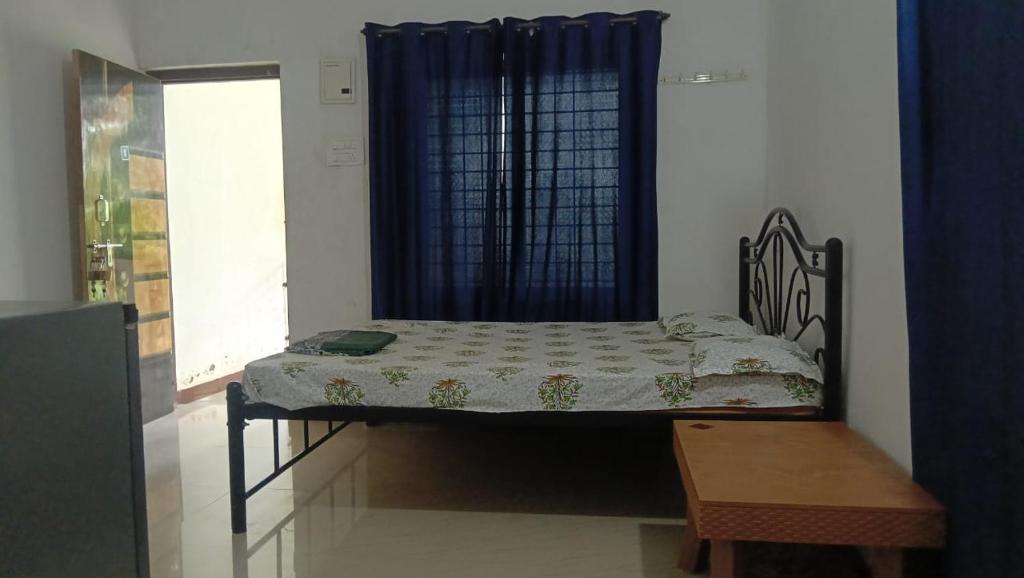 Una cama pequeña en una habitación con ventana. en Supriya holiday in, en Corgao