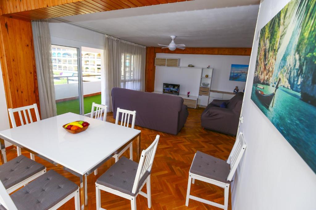 a living room with a white table and chairs at DELFINES Apartment in La Pineda