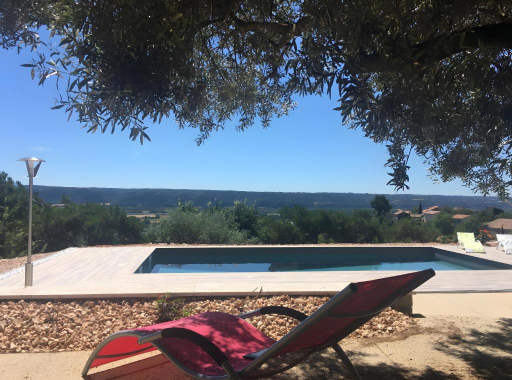 a chair sitting in front of a swimming pool at Villa Luxe – Vues panoramiques in Volx