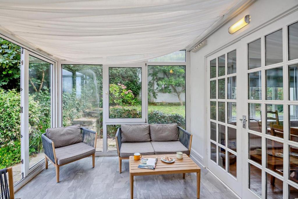 eine abgeschirmte Veranda mit 2 Stühlen und einem Tisch in der Unterkunft 3 Bed in Harlech oc-g33093 in Harlech