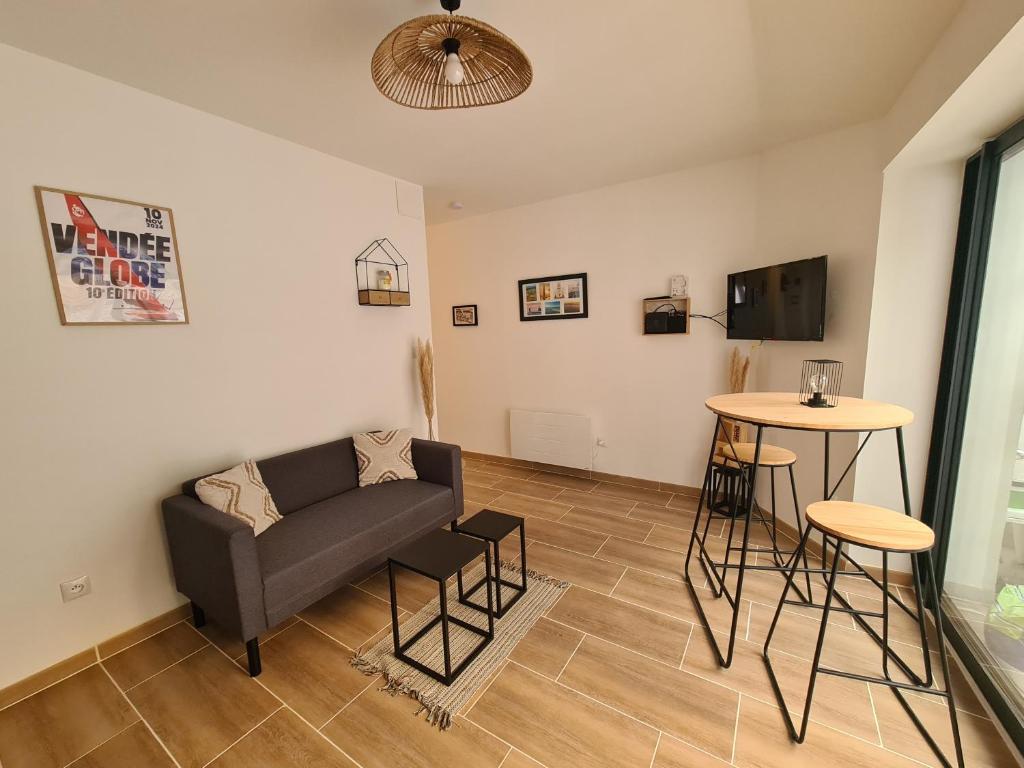 a living room with a couch and a table at La Maison du pont in La Roche-sur-Yon