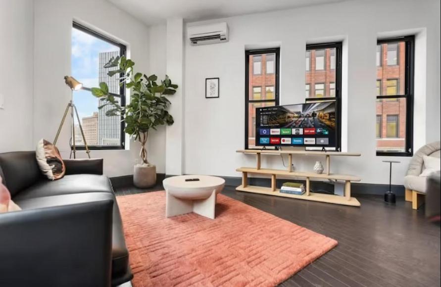 a living room with a couch and a tv at Elegant 2br In The Vibrant Heart Of Pittsburgh in Pittsburgh
