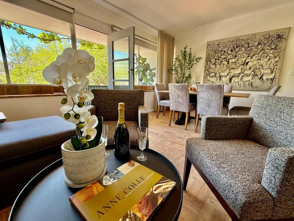a living room with a table with a bottle of wine at The Ya Ya Apartment in Stellenbosch