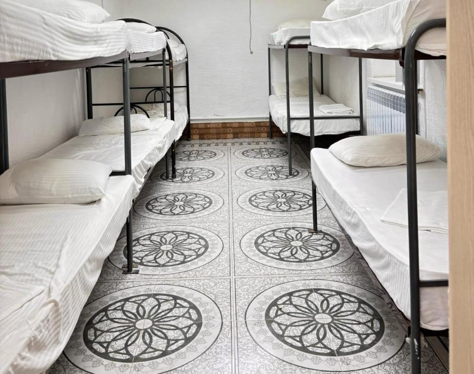 a room with three bunk beds and a tiled floor at Adeke hostel in Atyraū