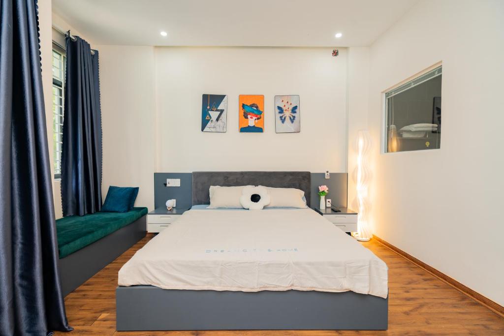 a bedroom with a bed and a green couch at Sơn Trà Homestay in Da Nang