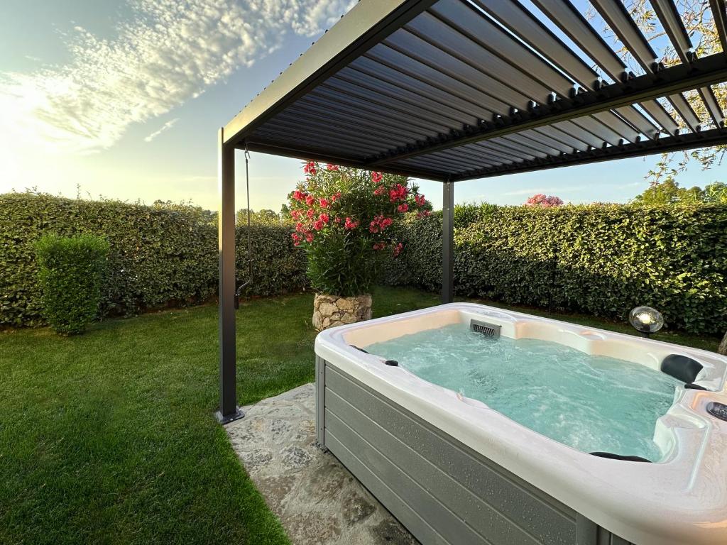 a hot tub under a pergola in a yard at Exclusive Getaways by SardegnaSummer in San Teodoro