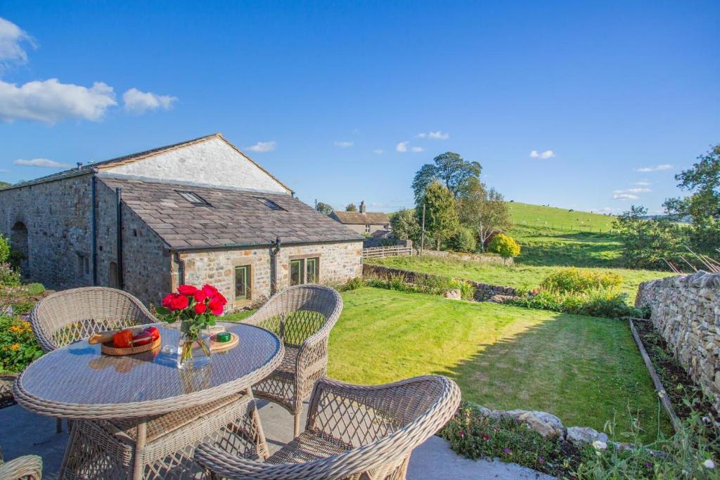 a patio with a table with flowers on it at 1 Bed in Bracewell oc-l33325 in West Marton