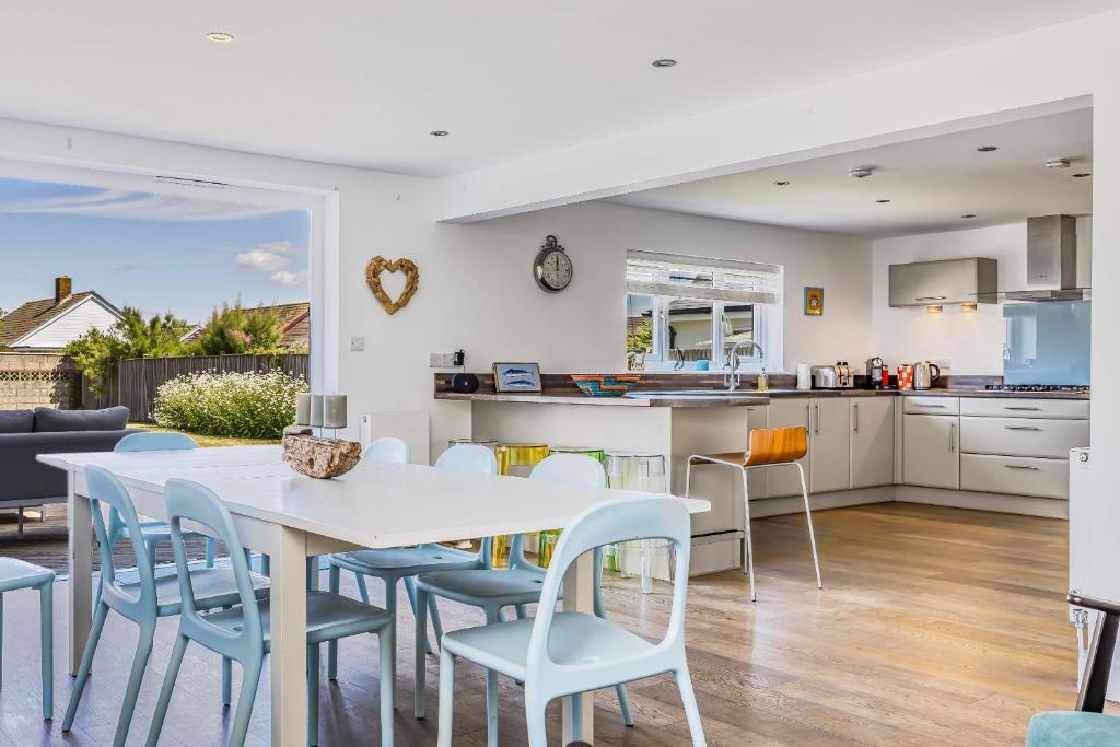 eine Küche und ein Esszimmer mit einem weißen Tisch und Stühlen in der Unterkunft Sundowner - West Wittering in East Wittering