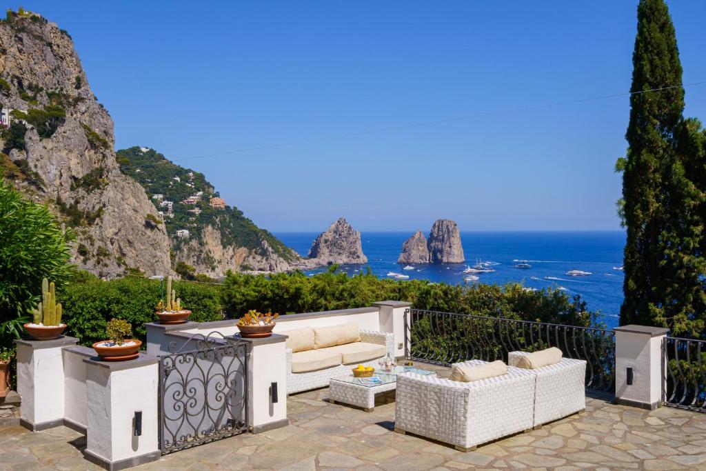 un patio con sofá y vistas al océano en Villa La Baika by MyVillaCollection, en Capri
