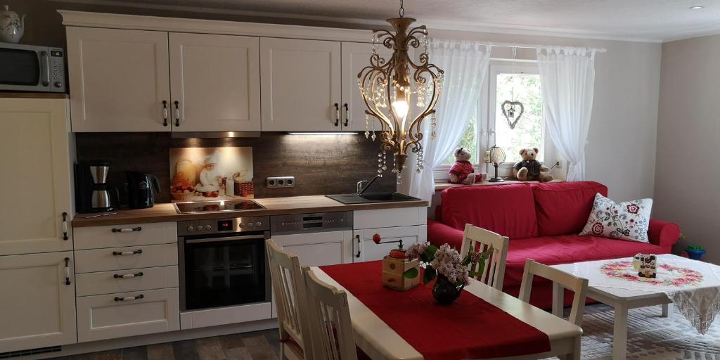 a kitchen and living room with a red couch and a table at Märchengarten Hänsel und Gretel in Putbus
