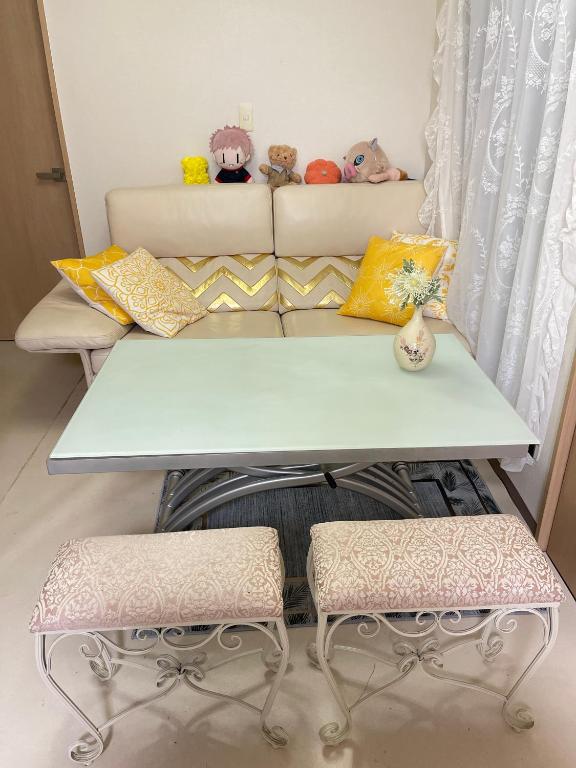 un tavolo bianco con due sedie e sopra degli animali di peluche di 望月ハウス201 a Tokyo