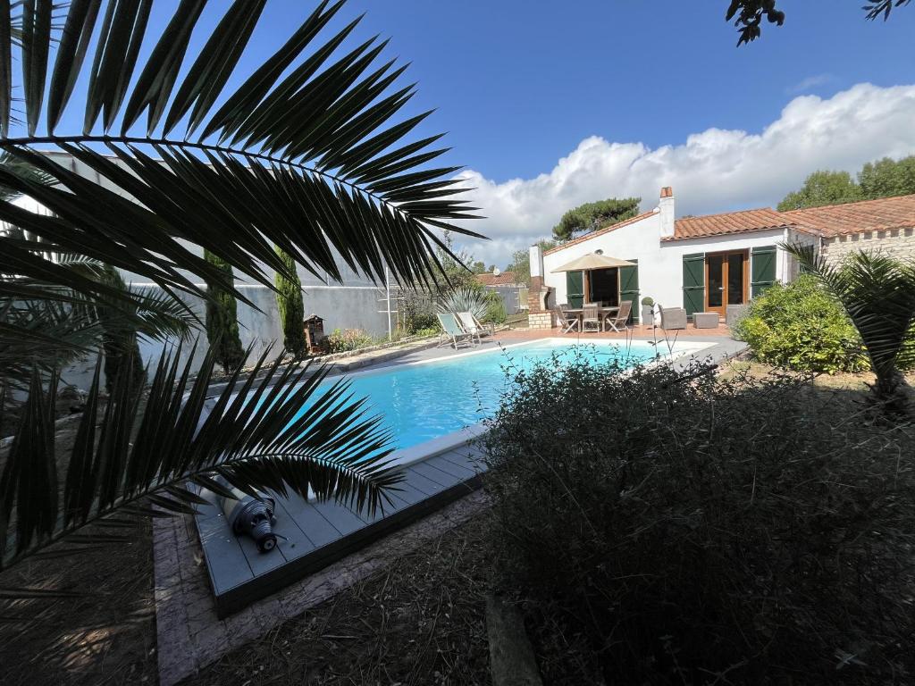 a swimming pool in front of a house at Villa de l Olivaie in Les Grenettes