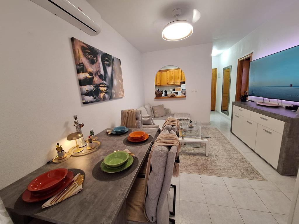 a kitchen and living room with a large wooden table at Solymar Torrevieja in Torrevieja