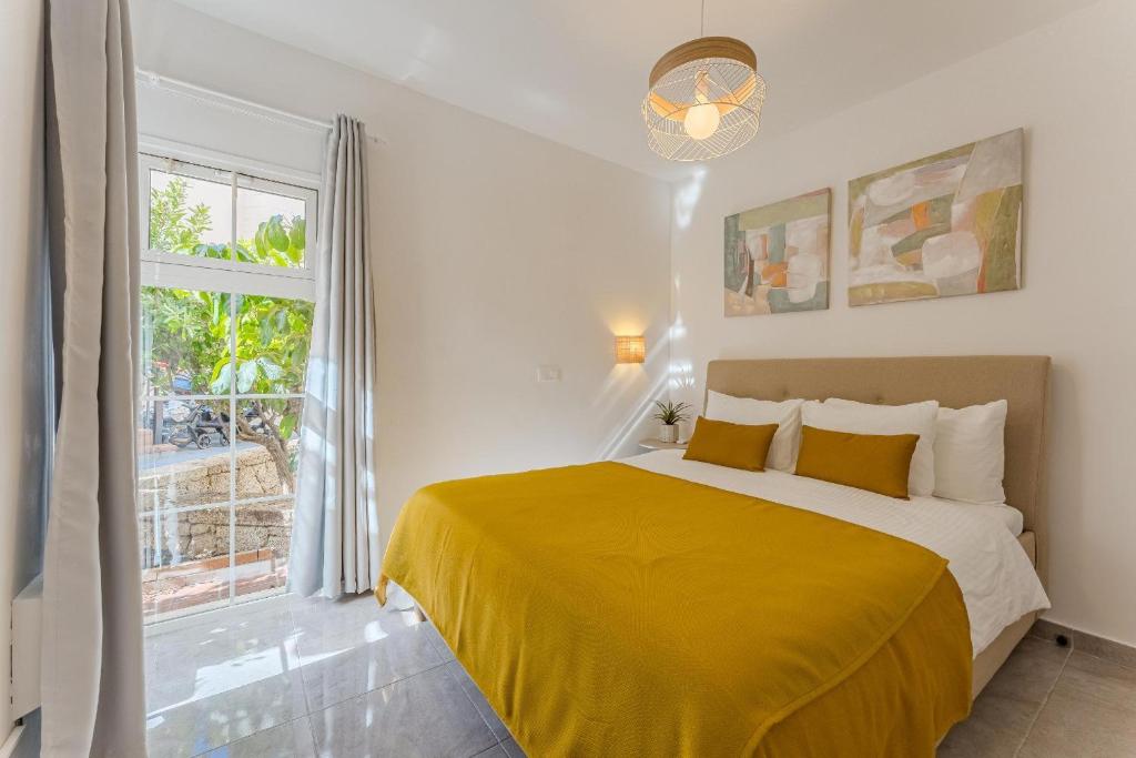 une chambre avec un lit jaune et une fenêtre dans l'établissement Yucca Park 1 Bed Apartment, à Adeje