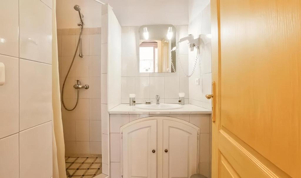 une salle de bains blanche avec un lavabo et un miroir dans l'établissement Camping Acqua E Sole, à Sainte-Lucie de Porto-Vecchio