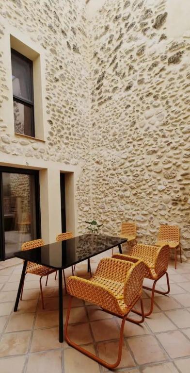 a patio with a table and chairs and a wall at Casa Lia in Alcocer de Planes