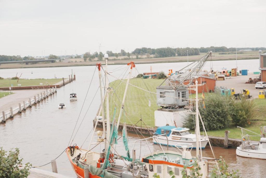 a boat docked next to a dock with other boats at Lexow - Hotel an de Havenkant in Tönning