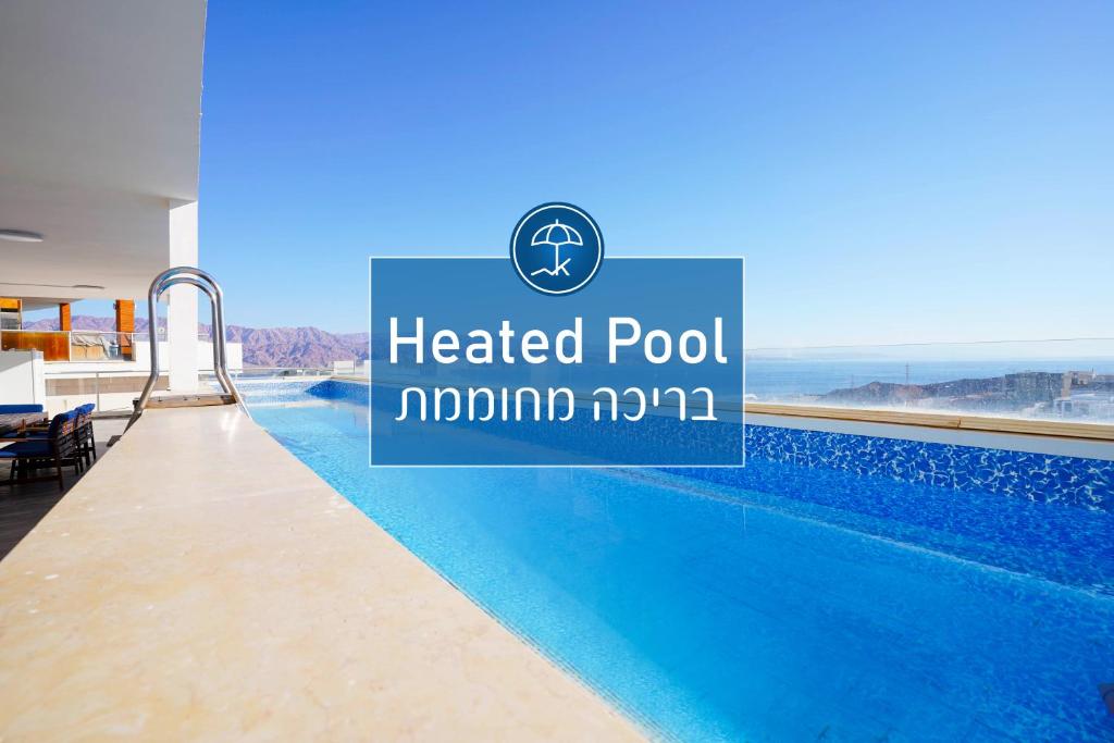 Una piscina de hotel con un cartel que dice piscina climatizada modalo en Exclusive Penthouse Eilat Private Pool and Panoramic View, en Eilat