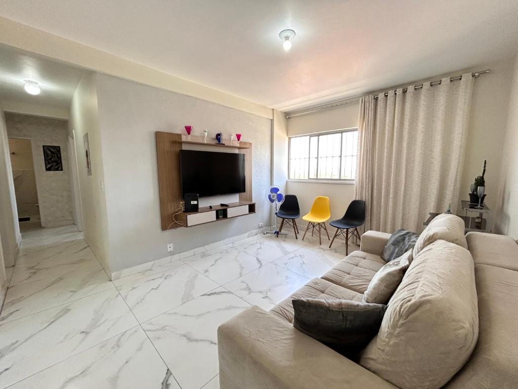 a living room with a couch and a flat screen tv at Apartamento de 3 quartos no setor Bueno na AV T 30 proximo da Videira in Goiânia