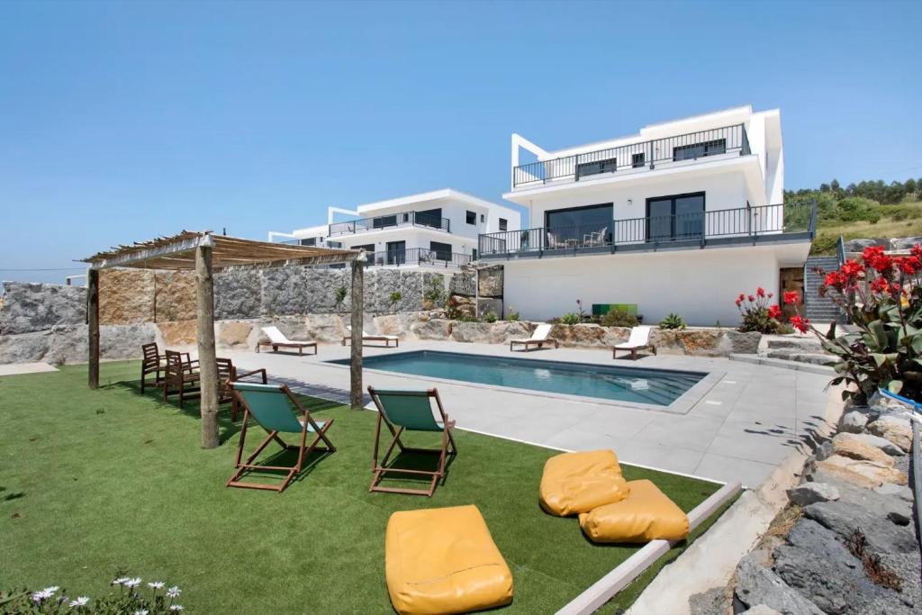 een villa met een zwembad en een huis bij Peace House Lourinhã in São Bartolomeu