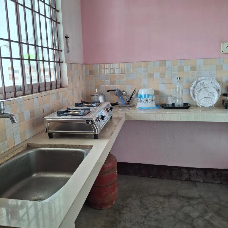a kitchen with a sink and a stove at Atithi Homestay in Sivasagar