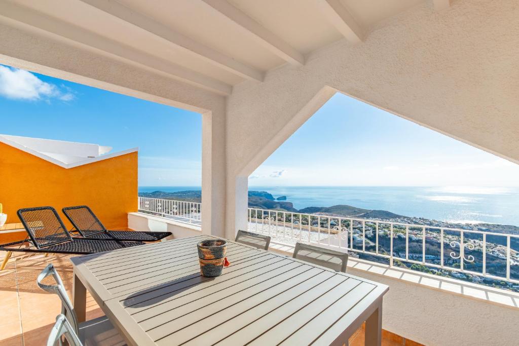 a balcony with a table and chairs and a view of the ocean at Vistamar 96 in Benitachell