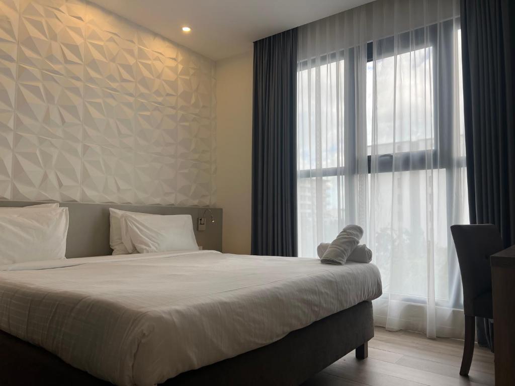 a bedroom with a bed and a large window at Adonis Cupecoy in Cupecoy