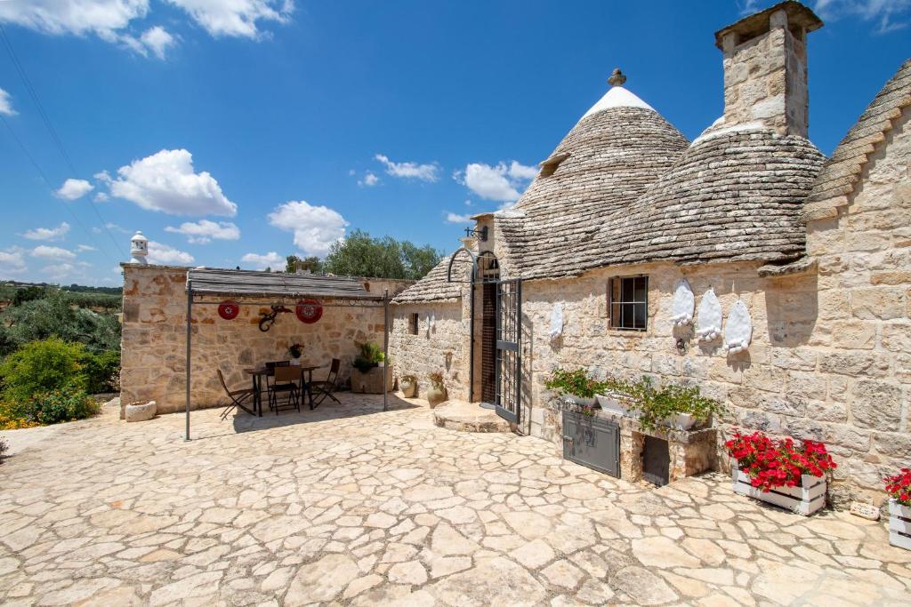 Elle offre une vue sur un bâtiment en pierre doté d'une terrasse. dans l'établissement Trullo Nurillo, à Alberobello