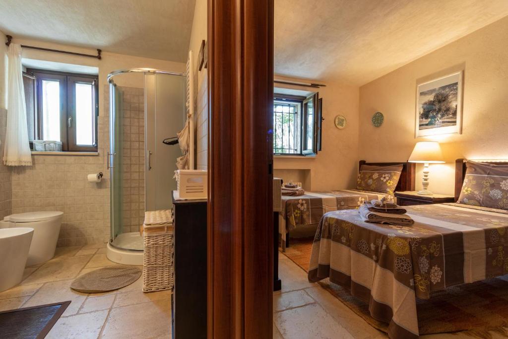 La salle de bains est pourvue de 2 lits et d'une douche. dans l'établissement Trullo Nurillo, à Alberobello