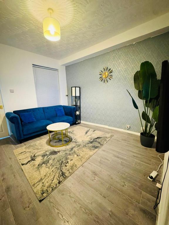 a living room with a blue couch and a table at Walsall Comfort Home 3Bedroom Retreat Sleeps 6 in Bescot