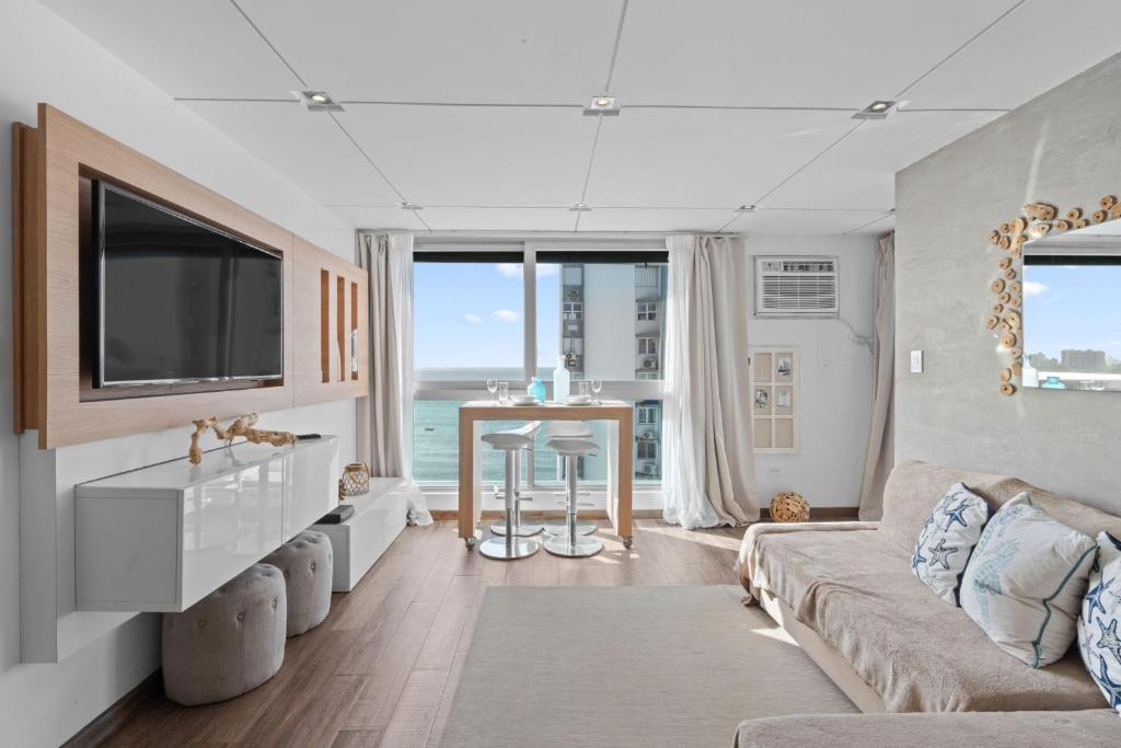 a living room with a couch and a tv at Beachfront Oceanview Wifi Self Check in in San Juan