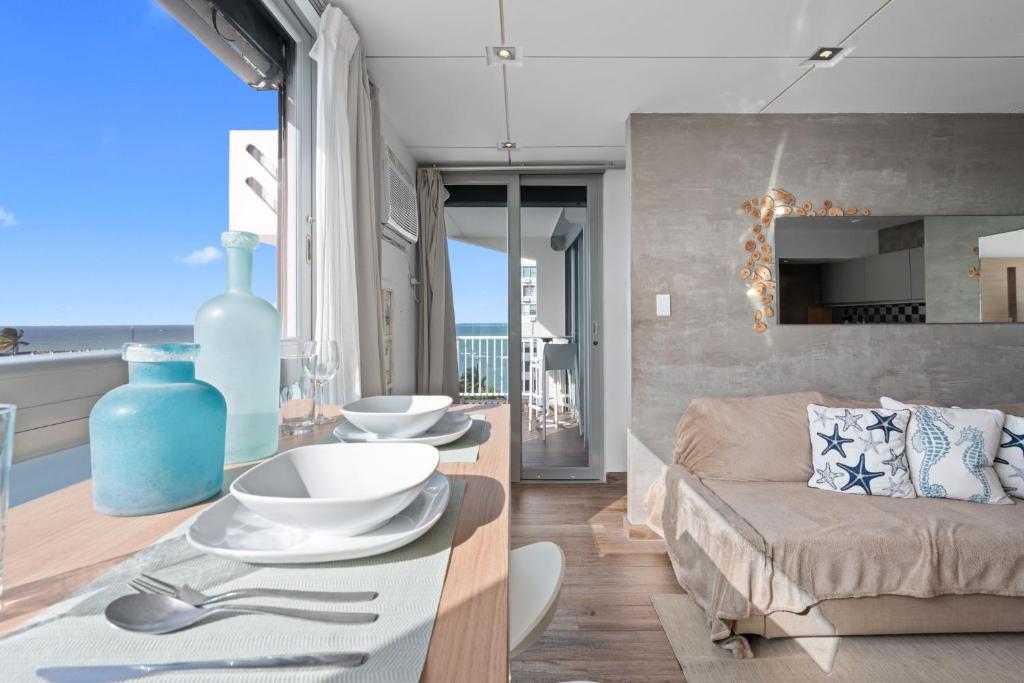 a living room with a couch and a table at Pr Rentals Beach Front Penthouse A 604 in San Juan
