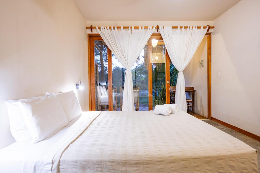 a bedroom with a large bed with a window at Hospedaje La Quebrada in Máncora