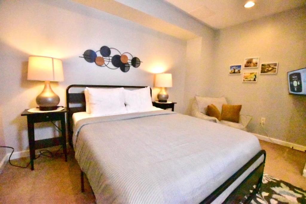 クリーブランドにあるTremont Apartmentのベッドルーム1室(大型ベッド1台、ランプ2つ、椅子付)