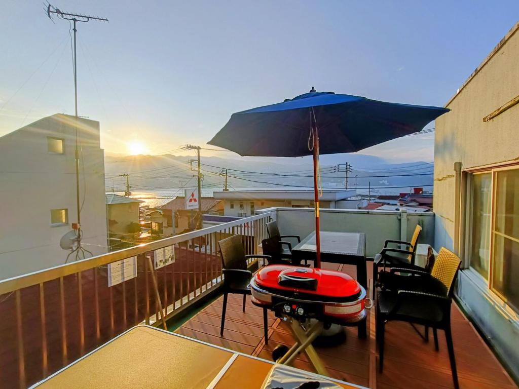 a balcony with a table and an umbrella at Atami Ajiro no kaze - Vacation STAY 40583v in Atami