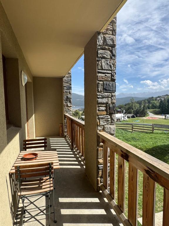 ein Balkon eines Hauses mit einem Tisch und Stühlen in der Unterkunft Nid douillet au pied des pistes in Les Angles