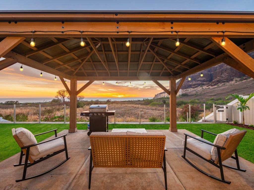 a patio with a table and chairs and a piano at Breath of Life by Kalo Homes in Makaha Valley