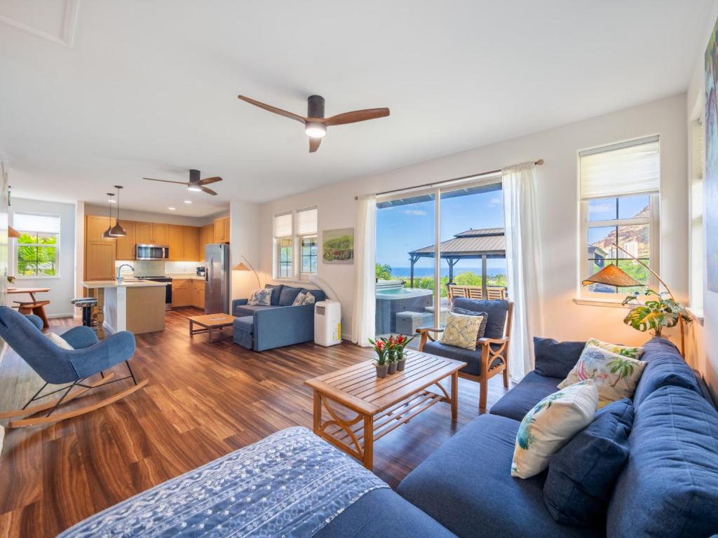a living room with a blue couch and chairs at Kalo Homes - Immersed in Aloha in Makaha Valley