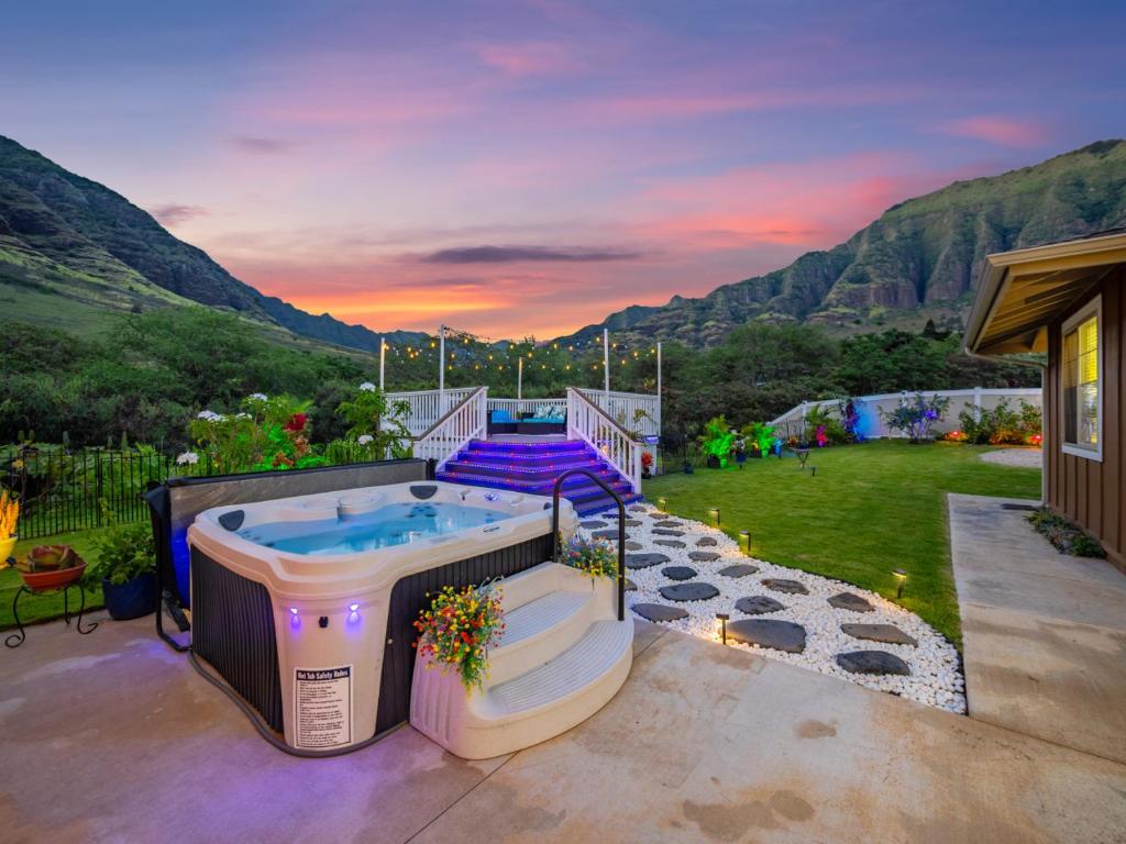 a hot tub on the patio of a house at Kalo Homes - Elevated Escape in Makaha Valley