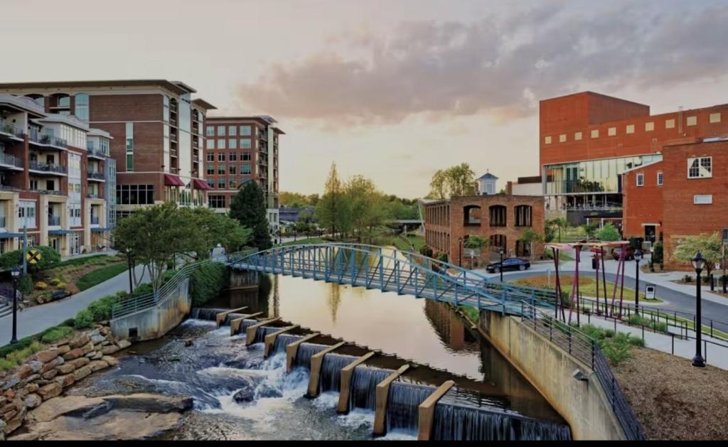 a bridge over a river in a city with buildings at Mins to Downtown, Hospital, Airport in Greenville