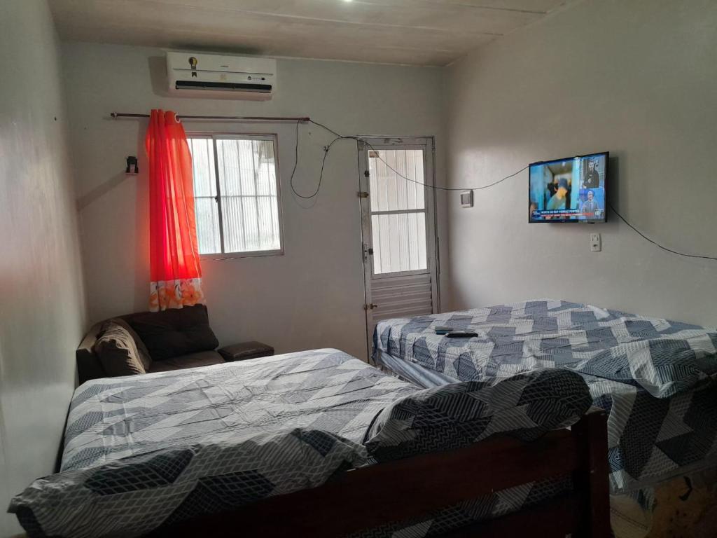 a bedroom with two beds and a couch and a window at Suíte com 2 camas de casal para Cop30 in Belém