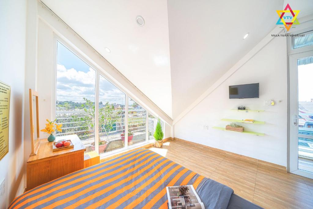 une chambre avec un lit et une grande fenêtre dans l'établissement Villa Tuan Vu Da Lat - Retreat, à Đà Lạt