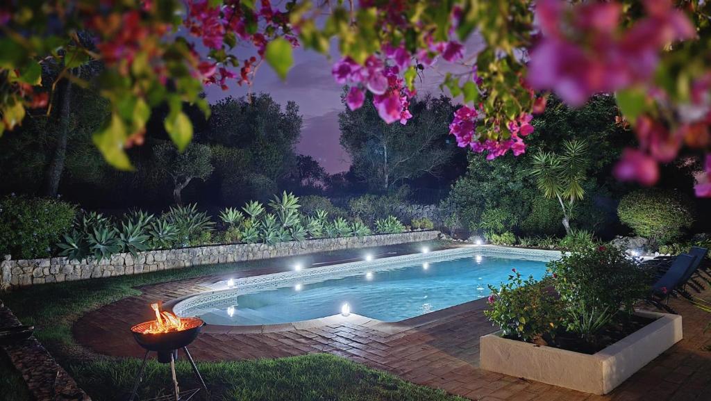 une piscine avec un feu dans un jardin dans l'établissement Villa Gwendolin, à Portimão