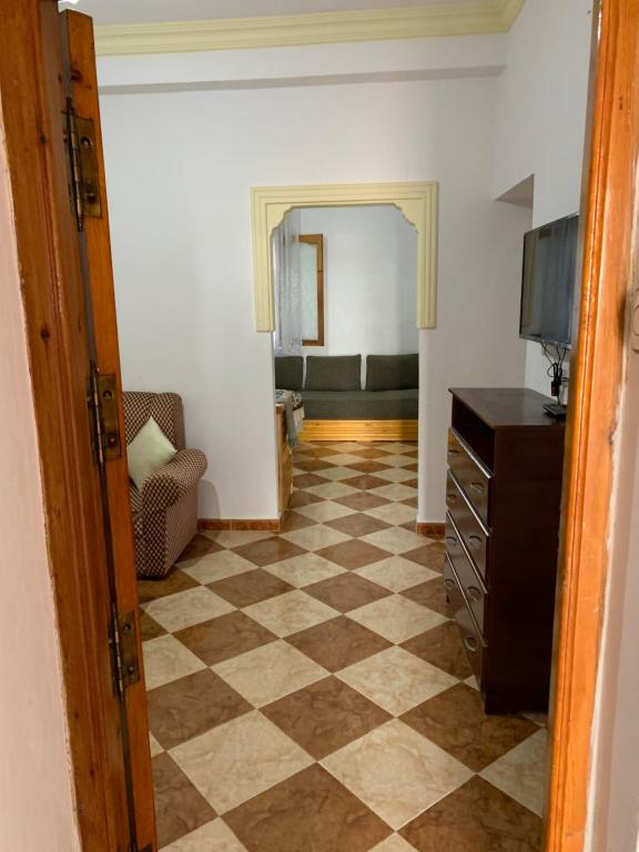 a hallway with a living room with a checkered floor at Zellaka apartamento2 in Asilah