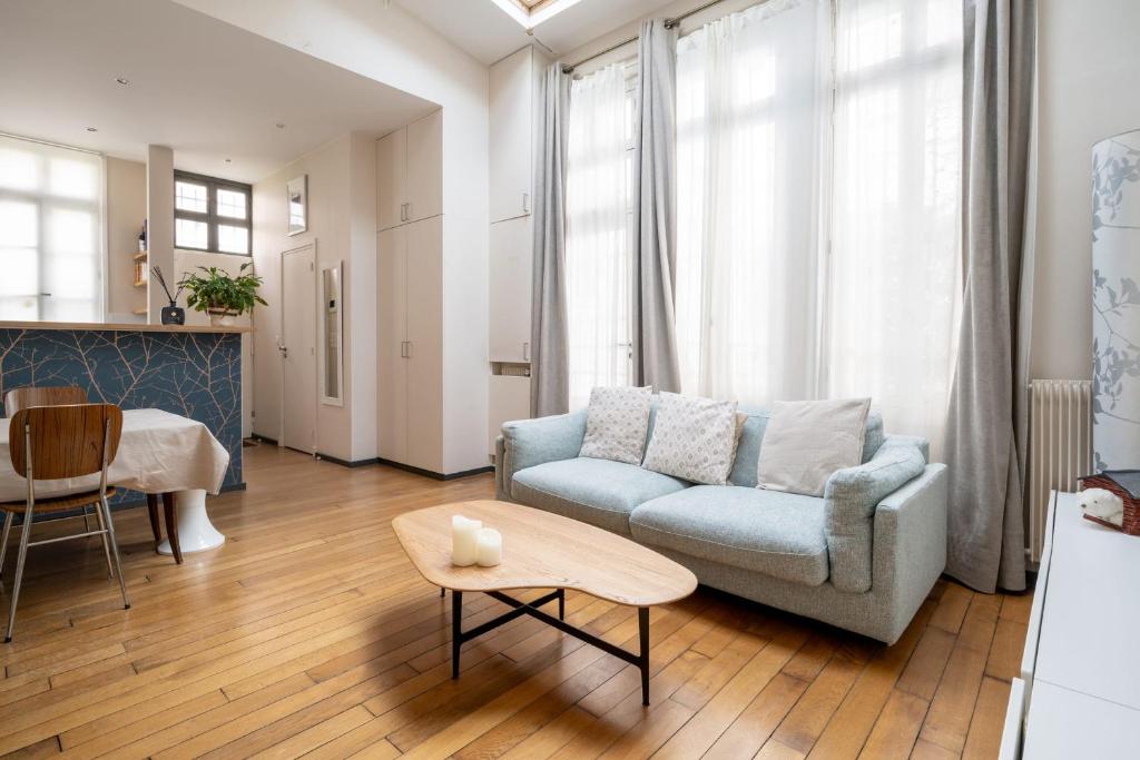 a living room with a couch and a table at Maison Loft Verzy - Nomad by Welkeys in Paris