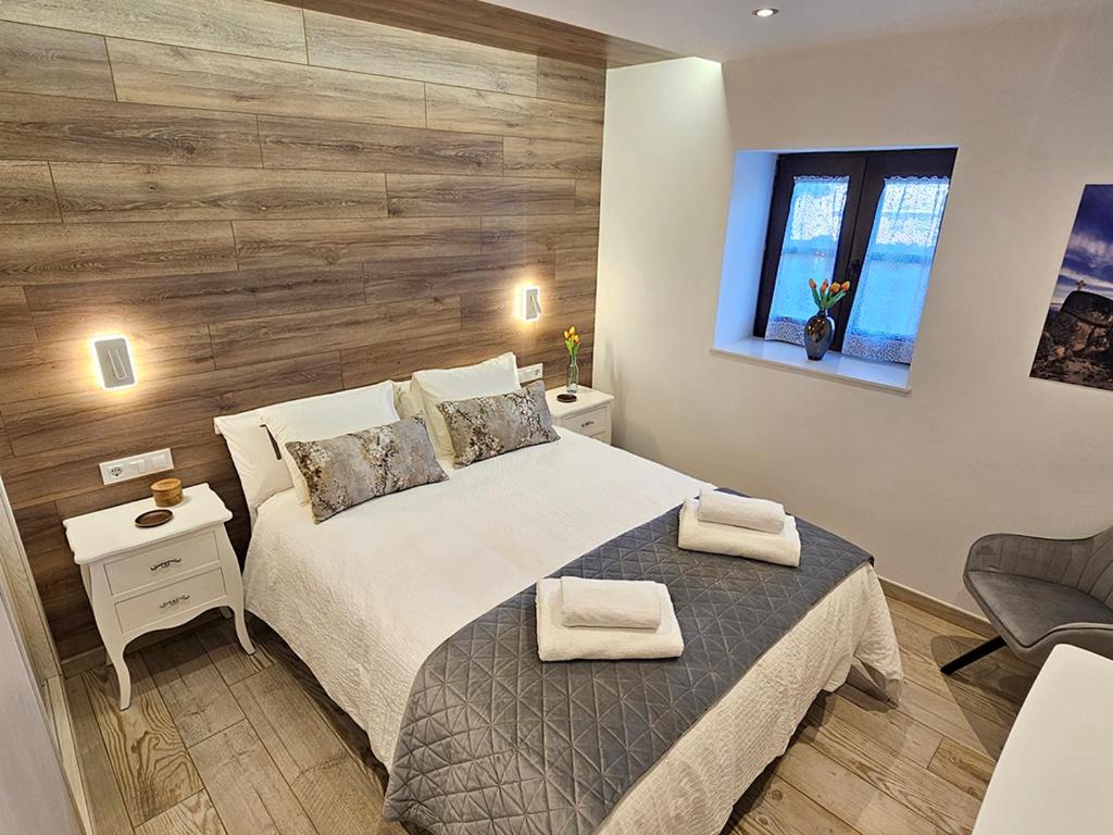 a bedroom with a bed and a wooden wall at Mural del Castillo II, La Alberca in La Alberca