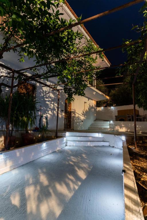 a swimming pool in front of a house at night at Tasos Apartment in Leonidio