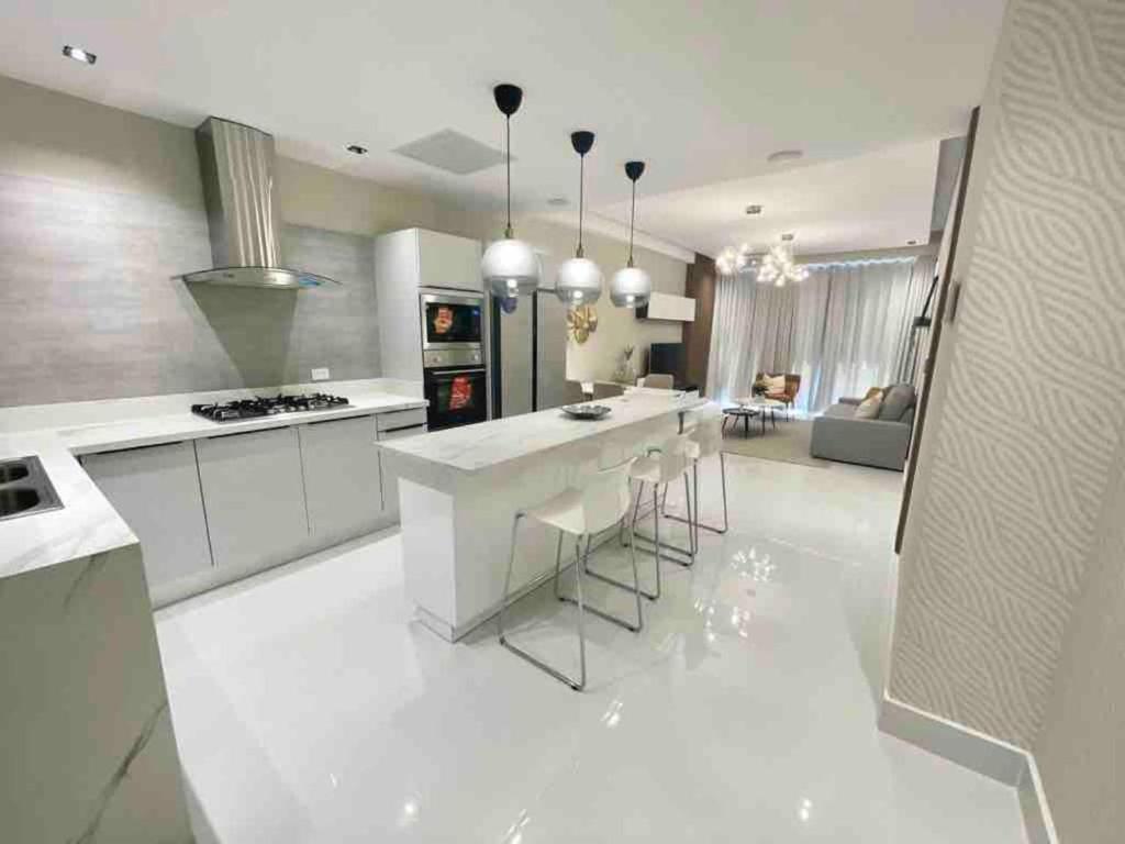 una grande cucina bianca con bancone e sedie di Upscale City Center Condo a Carlos Guerra