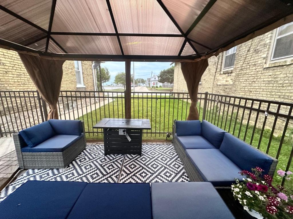un patio con 2 sofás azules y una mesa en Lake Michigan Dreamscape, en Racine